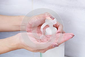 Female hands using wash hand sanitizer gel pump dispenser.