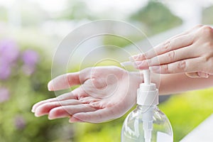 Female hands using wash hand sanitizer gel pump dispenser.