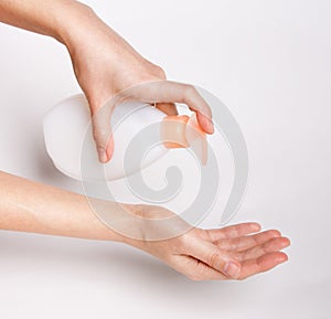 Female hands using wash hand sanitizer gel pump dispenser