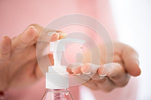 Female hands using wash hand sanitizer gel pump dispenser for prevention Coronavirus disease COVID-19. Healthcare and photo