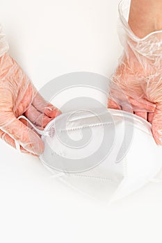 Female hands wearing vinyl gloves  holding KN-95 protection face masks.