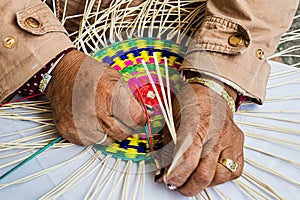 Female hands weaving a placemat from Paja Toquilla Straw photo