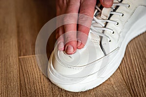 Female hands with wet wipe stain excretion from leather shoes.