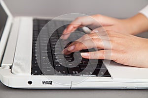 Female hands on a white computer keyboard