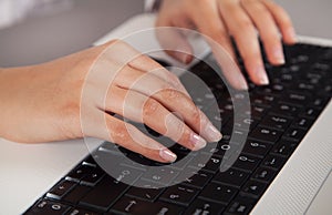 Female hands on a white computer keyboard