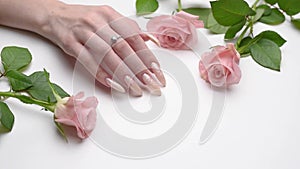 Female Hands on a white silk background with beautiful pearl manicure