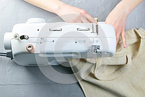 Female hands work on a sewing machine, sewing coffee towel. Close-up