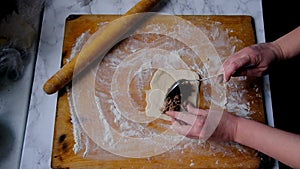 Female hands are working with the dough