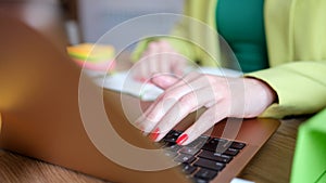 Female hands works on laptop keyboard in office