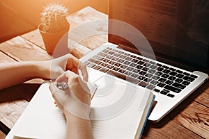 Female hands write to notebook