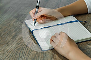 Female hands are writing in a notebook