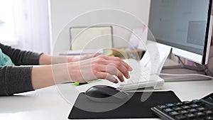 Female hands writing on notebook and using pc. typing on keyboard close up. Woman freelancer working at home office