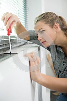 female handyman using screwdriver