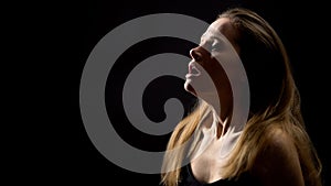 Female hardly breathing, suffering asthma attack, isolated on black background photo