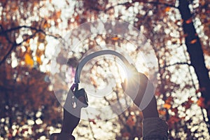 Female with headphones walking on the park listen sounds or music of autumn forest. Concept. Indian summer