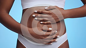 Female health and fertility concept. Close up shot of young unrecognizable african american woman touching her belly