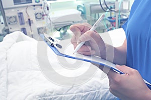 Female health worker writing some notes in the hospital ward