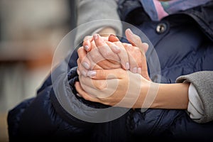 Female healthcare worker holding hands of senior woman during the walk