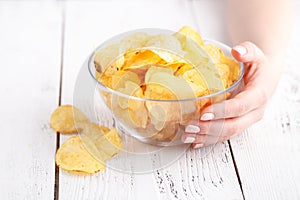 Female with heap of potato chips in big dish