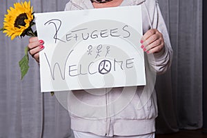 Female helper welcomes refugees with sunflower photo