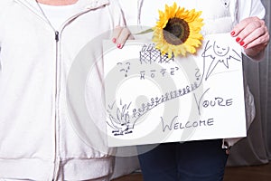 Female helpers welcome refugees with sign