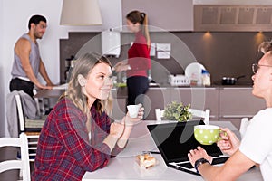 Female helping guy to plan tourist itinerary at hostel kitchen