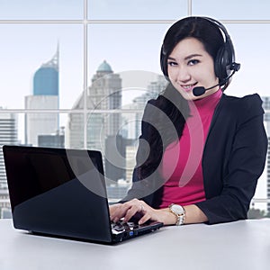 Female helpline operator with laptop