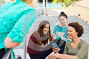Female High School Students Sitting Outside Building