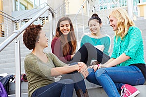 Female High School Students Sitting Outside Building