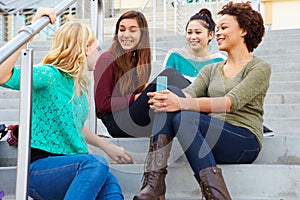 Female High School Students Sitting Outside Building