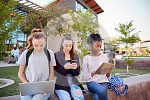 Female High School Students Using Digital Devices Outdoors During Recess photo