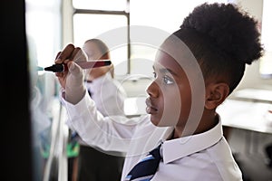 Female High School Students Wearing Uniform Using Interactive Whiteboard During Lesson