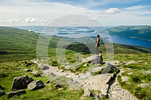 Female hiker admiring the landscape on a path leading to the top photo