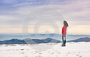 Female hiker admiring winter scenery on a mountaintop