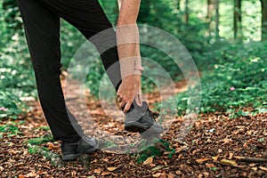Female hiker with ankle injury in forest