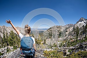 Female hiker with backpack along the Sawtooth Lake trail in Idaho. Back facing camera. Concept for solo female travel and hiking photo