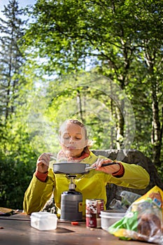 Female hiker/climber preparing supper on gas burner