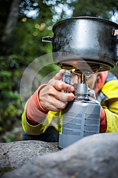 Female hiker/climber preparing supper on gas burner