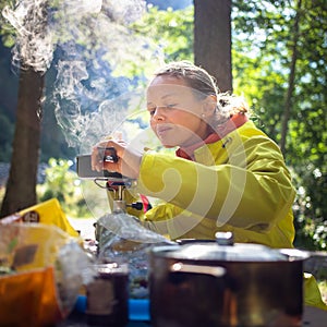 Female hiker/climber preparing supper on gas burner