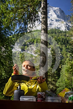 Female hiker/climber preparing supper on gas burner