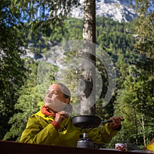 Female hiker/climber preparing supper on gas burner