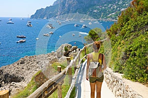 Female hiker descent the pathway with spectacular landscape of Capri, Naples, Italy