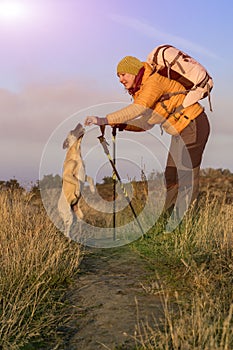 Female hiker and dog on pathway