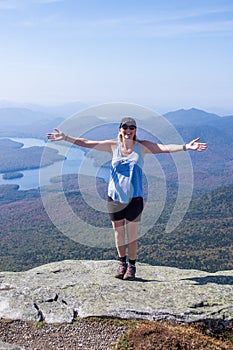 Female hiker with her arms out at the summit of Whiteface Mountain