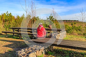 Female hiker with her dachshund taking break at rest area and viewing point