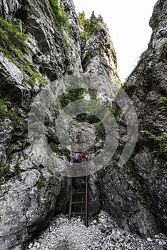 Female hiker on ladder on a rocky hiking trail in Prosiecka valley, Slovakia