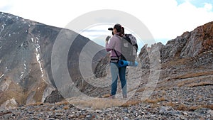 Female Hiker Looking Through Binoculars on Cliff