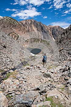 A female hiker makes her way down a dangerous hiking path of talus and rock scree photo