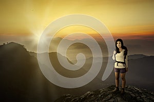 Female hiker on a mountain with sunset