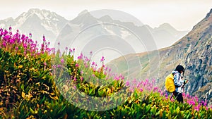 Female hiker with nordic walk pols hike downhill in green caucasus mountains hiking trail in spring nature rainy day.Recreational photo